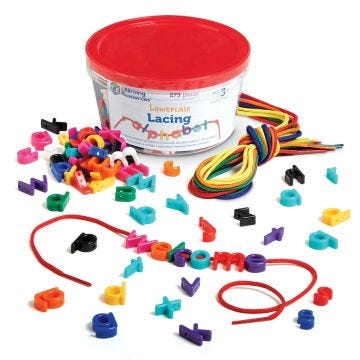 an open container of  scattered lowercase lacing alphabets with a group of rainbow-colored laces on a white back ground