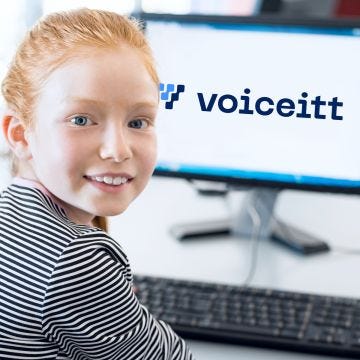 Girl sits in front of computer monitor with logo of voiceitt