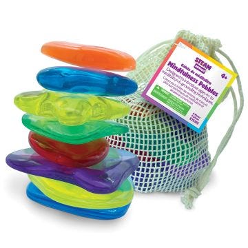 A vibrant stack of assorted plastic toys beside a bag;  showcasing a variety of colors and playful designs.
