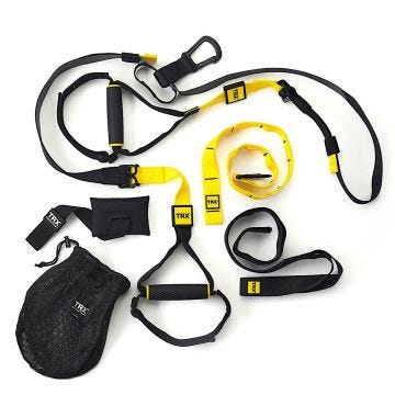 17378PS_00 = TRX Suspension Trainer set laid out on a white background, including yellow and black straps, rubber handles, an adjustable anchor system, a door anchor, and a black mesh carrying bag.