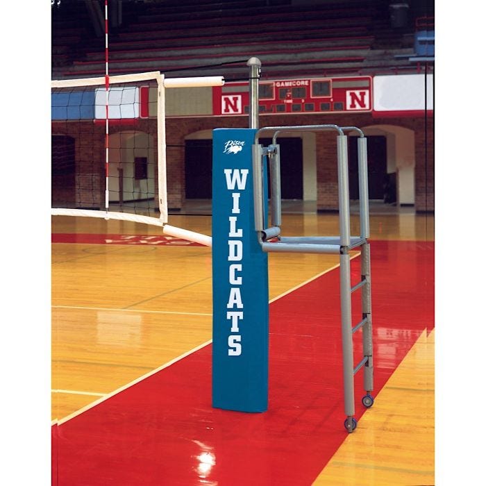 The front view of the Bison Centerline Elite Steel Hybrid Double Court System with padding pictured on a volleyball court with a sideline attached. The front view of the Bison Centerline Elite Steel Hybrid Double Court System with padding pictured on a volleyball court with a sideline attached.
