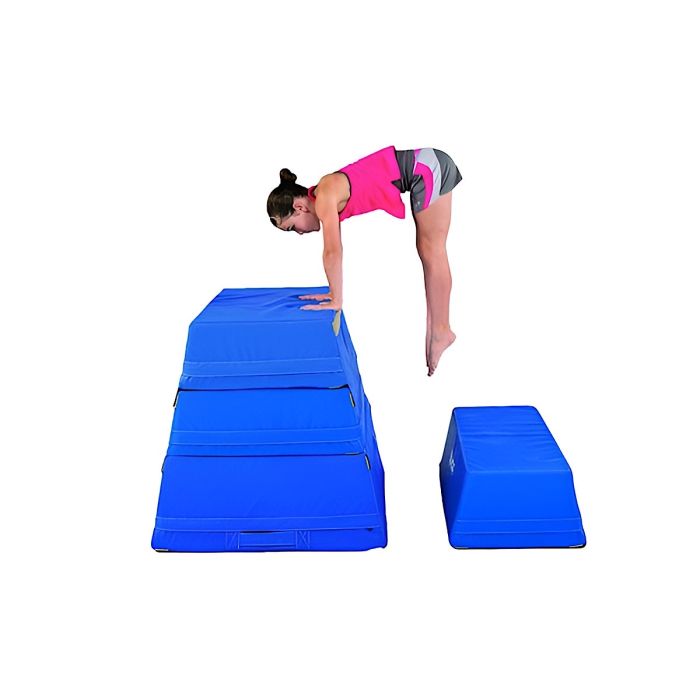 A young female gymnast preparing a handstand atop a 3-layer blue gymnastics trapezoid. A young female gymnast preparing a handstand atop a 3-layer blue gymnastics trapezoid.